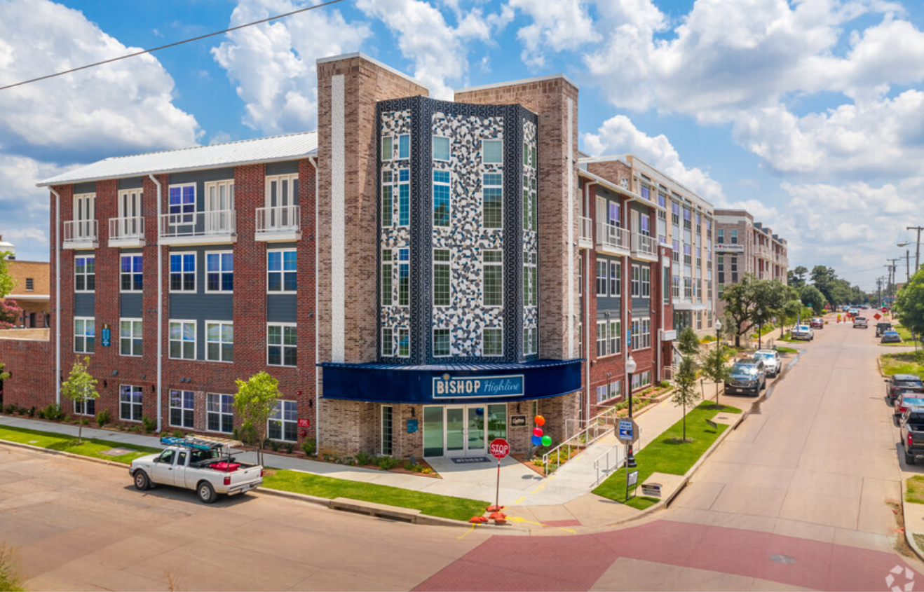 Street corner view of building with cars out front